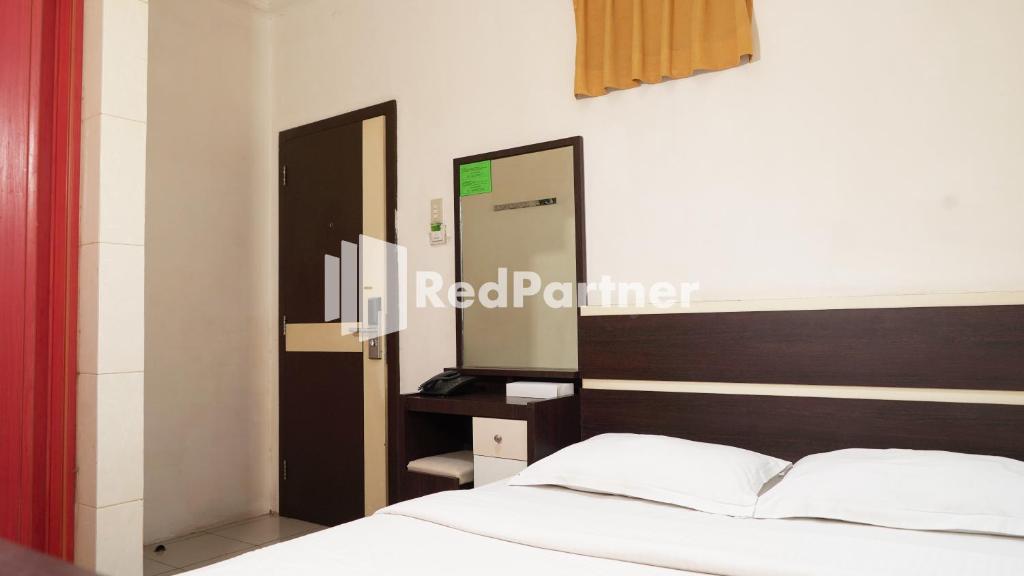 Postel nebo postele na pokoji v ubytování Wisma Sederhana Medan Mitra RedDoorz