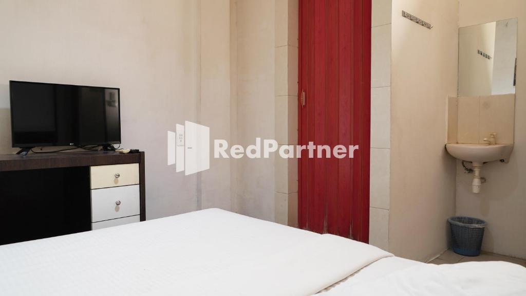 Postel nebo postele na pokoji v ubytování Wisma Sederhana Medan Mitra RedDoorz