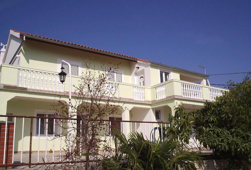 Cette maison blanche dispose d'un balcon. dans l'établissement Apartments by the sea Tisno, Murter - 13588, à Tisno