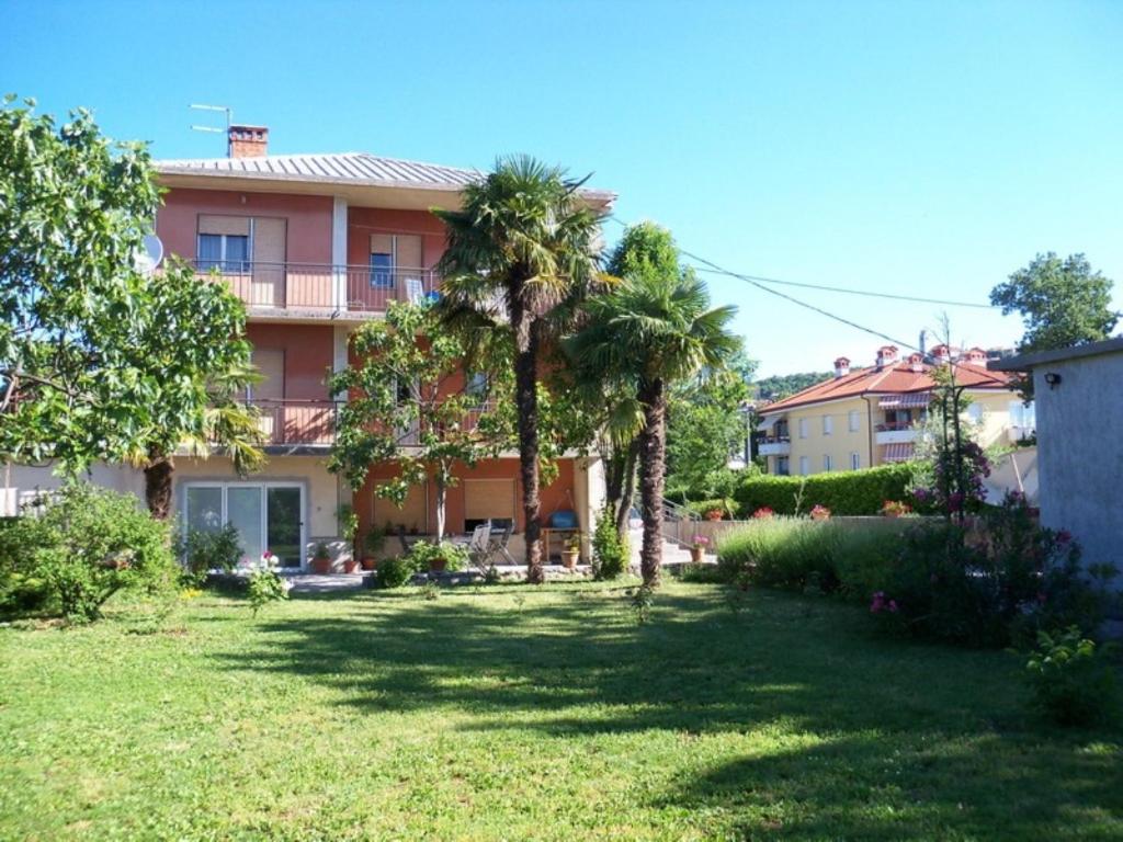 a large house with palm trees in the yard at Apartments with a swimming pool Kastav, Opatija - 13638 in Kastav