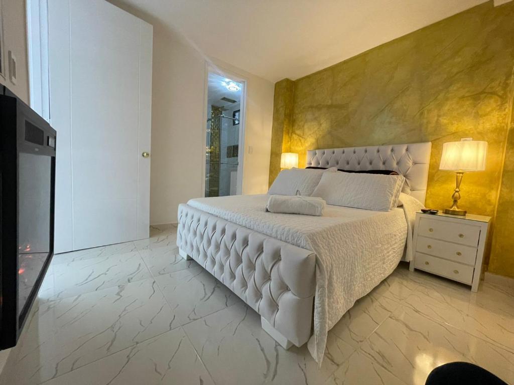 um quarto com uma grande cama branca e uma televisão em CASABOUTIQUE HOTEL em Salento