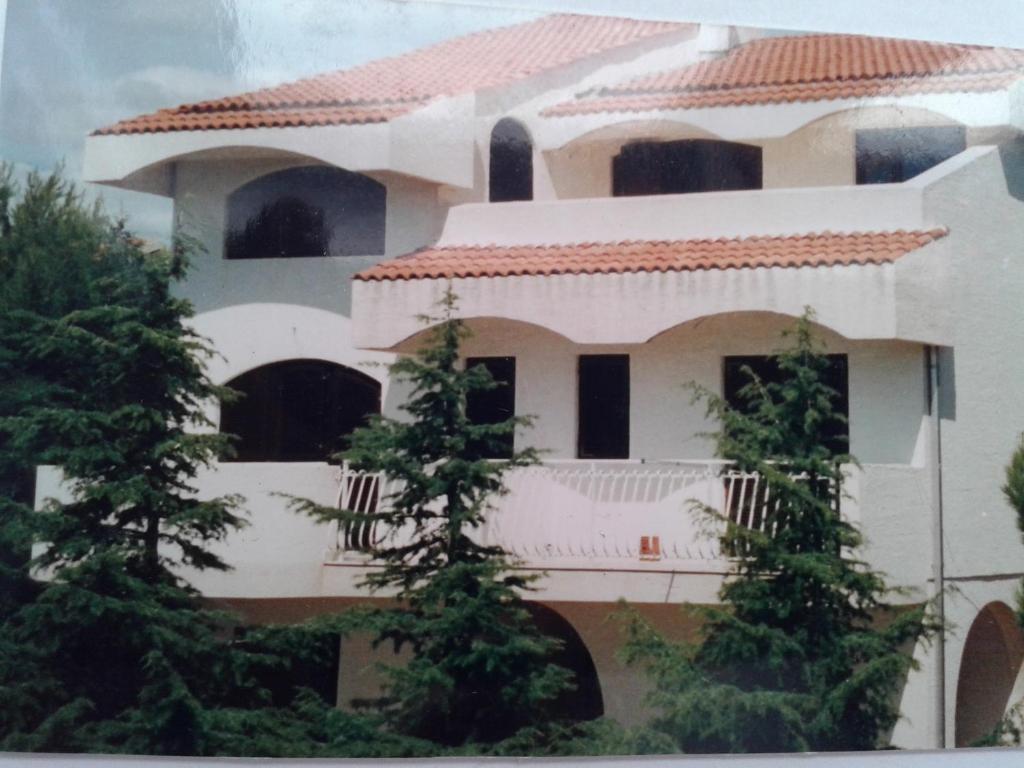 een groot wit gebouw met een rood dak bij Apartments with a parking space Primosten - 13671 in Primošten