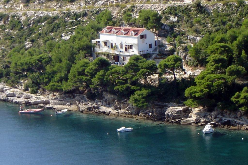ein Haus auf einem Hügel mit Booten im Wasser in der Unterkunft Apartments by the sea Prapratno (Peljesac) - 13500 in Ston