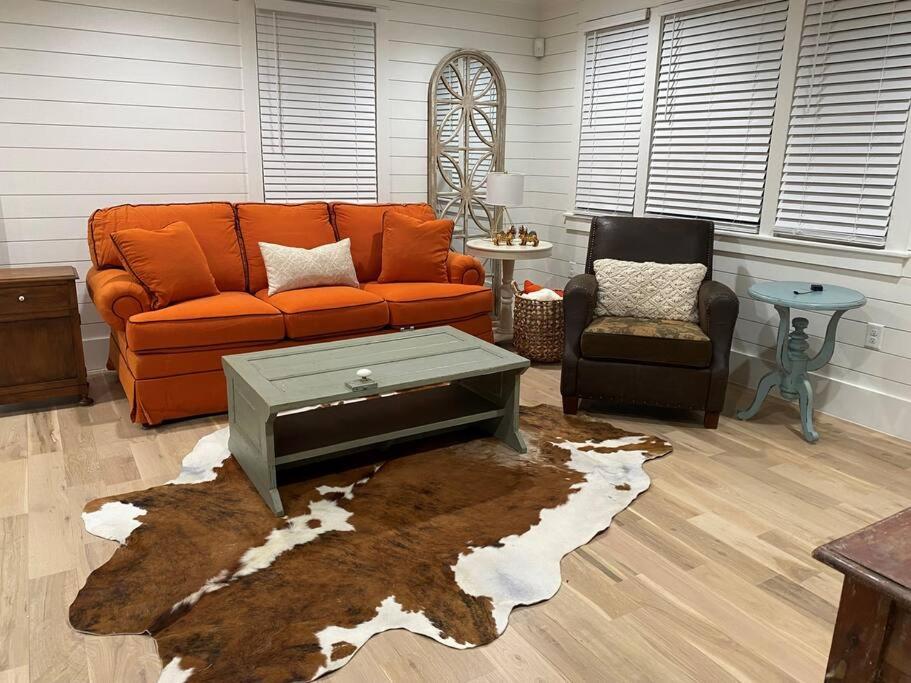 ein Wohnzimmer mit einem orangenen Sofa und einem Teppich in der Unterkunft Walk to Bay Street and Historic Downtown Beaufort! Close to Parris Island MCRD!! in Beaufort