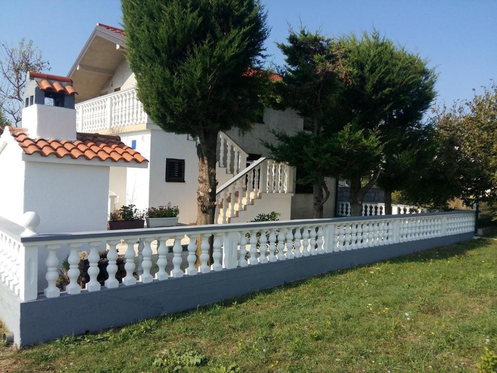 een wit hek voor een huis bij Apartments with a parking space Sabunike, Zadar - 14574 in Nin
