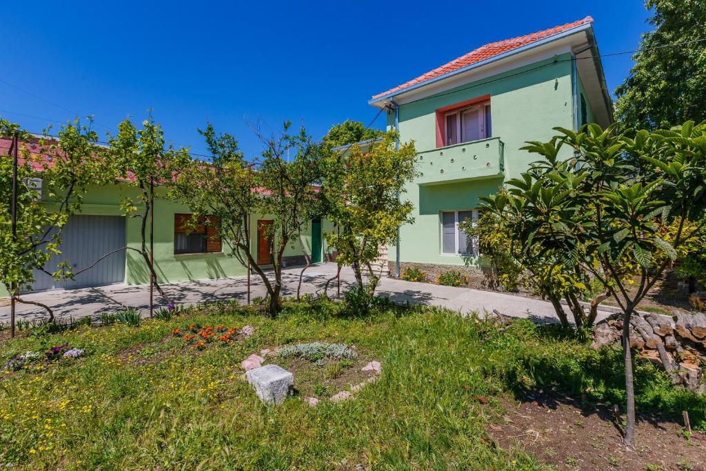 a green house with trees in front of it at Apartments by the sea Kastel Stari, Kastela - 14577 in Kaštela