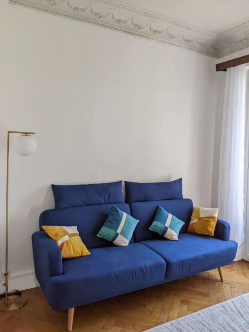 a blue couch with pillows in a living room at Amazing 2-bedroom apartment in Nice near the beach in Nice