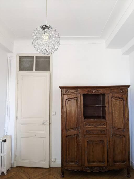 a room with a large wooden cabinet and a chandelier at Amazing 2-bedroom apartment in Nice near the beach in Nice