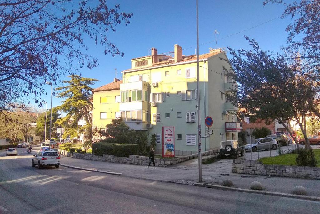 un grand bâtiment blanc sur le côté d'une rue dans l'établissement Apartments with WiFi Split - 14594, à Split
