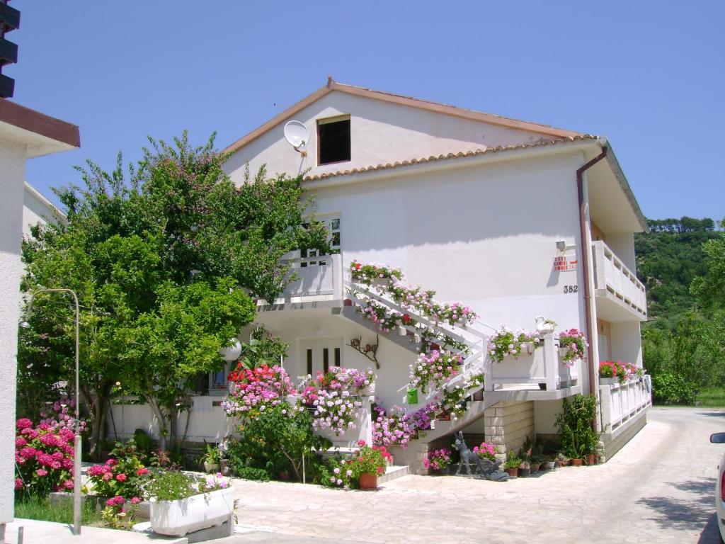 une maison avec des fleurs devant elle dans l'établissement Apartments with a parking space Palit, Rab - 14610, à Rab