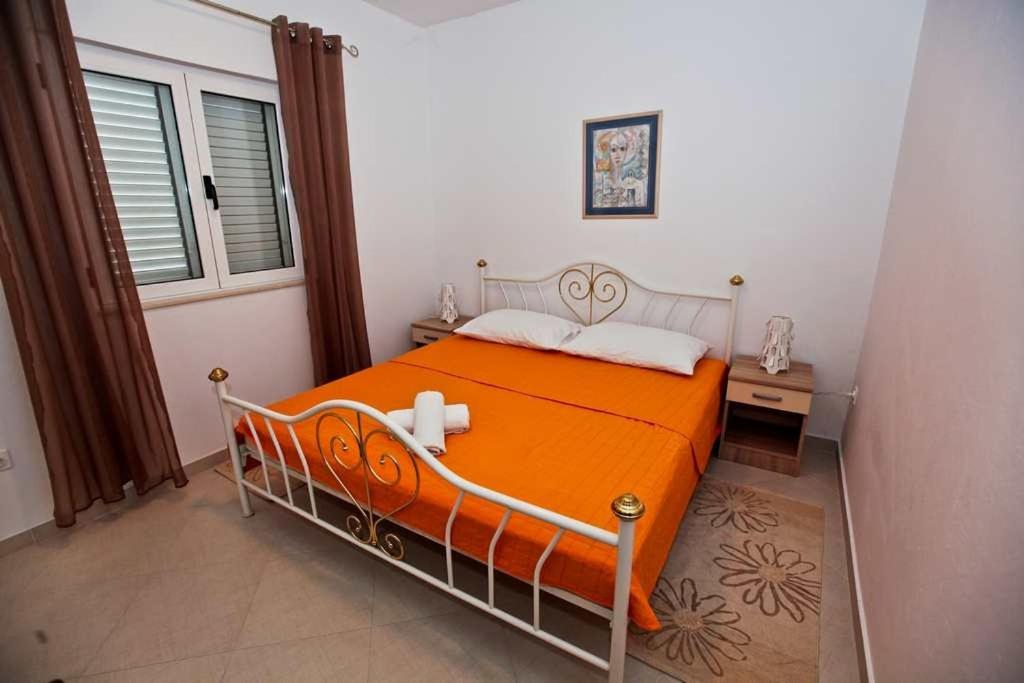 pomarańczowe łóżko w pokoju z oknem w obiekcie Apartments by the sea Pakostane, Biograd - 14658 w Pakoštane