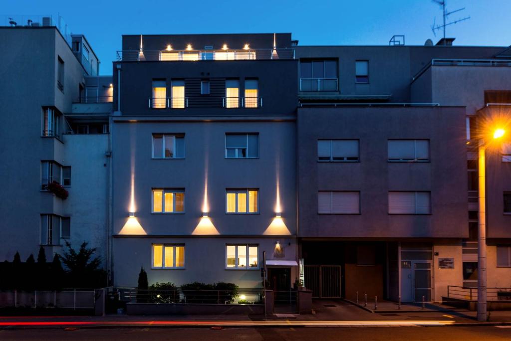 a building with lit up windows and a street light at Apartments and rooms with WiFi Zagreb - 14675 in Zagreb