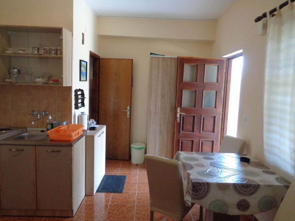 a kitchen with a table and a kitchen with a door at Studio Sukosan 14681a in Sukošan