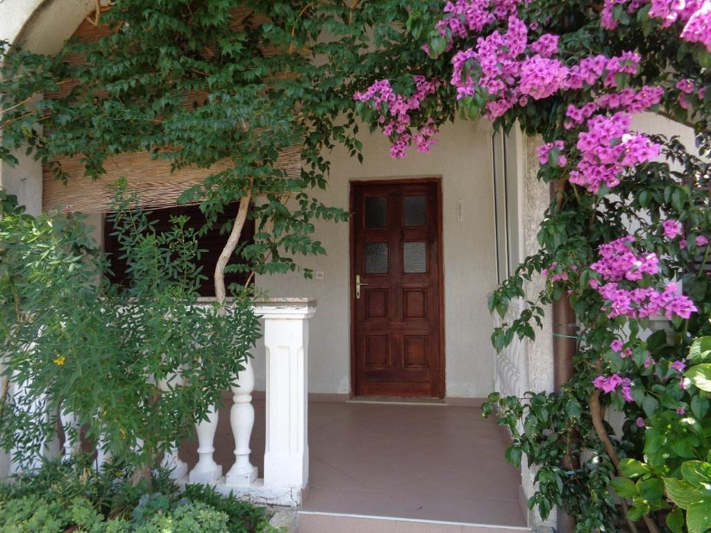 an entrance to a house with pink flowers at Studio Sukosan 14681a in Sukošan