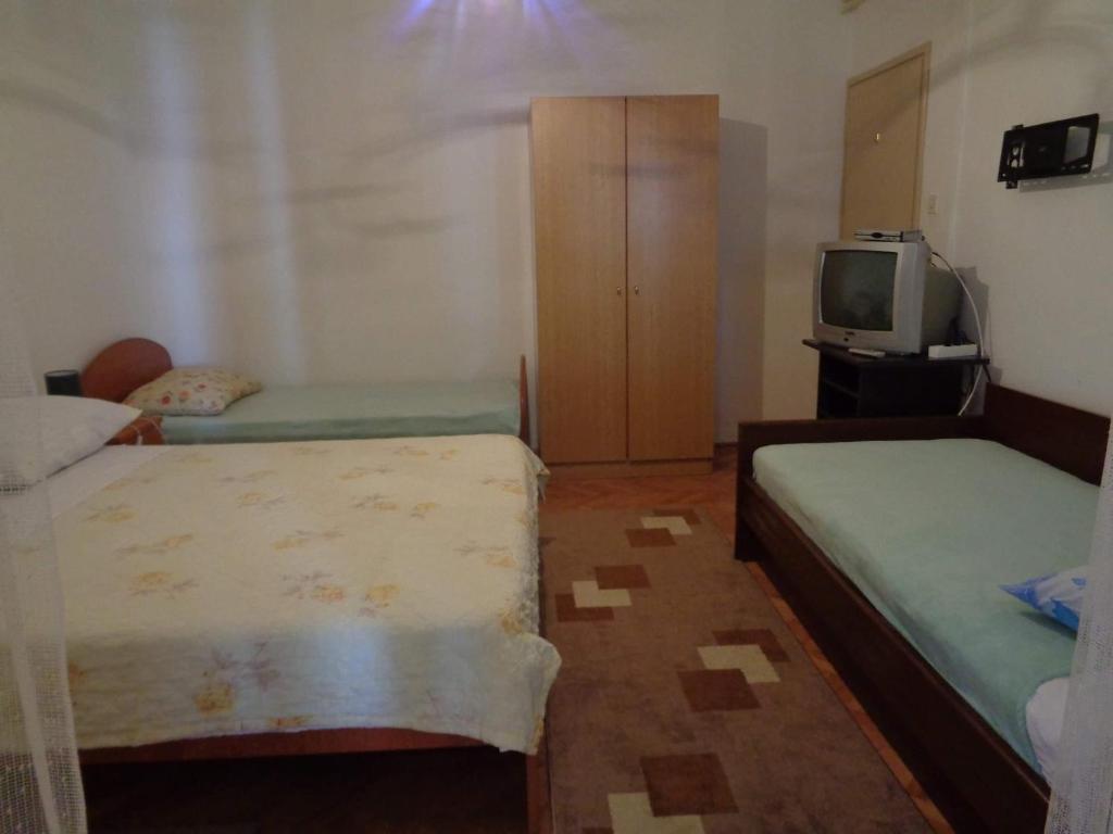 a small room with two beds and a tv at Studio Sukosan 14681b in Sukošan