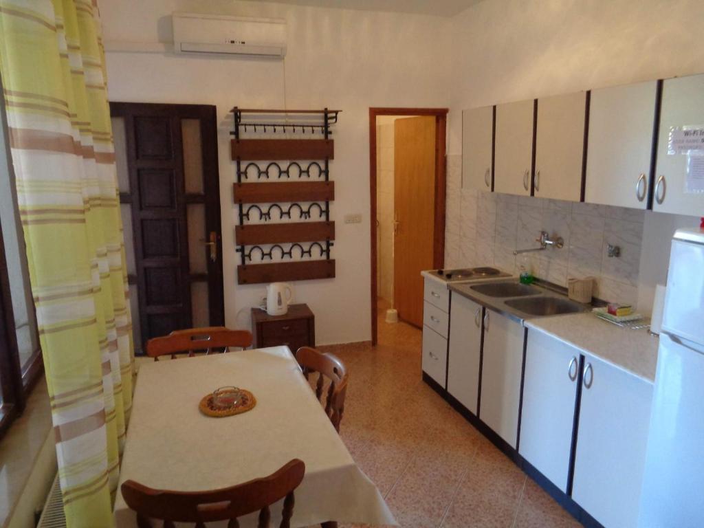 a kitchen with a table and a sink and a refrigerator at Studio Sukosan 14681b in Sukošan
