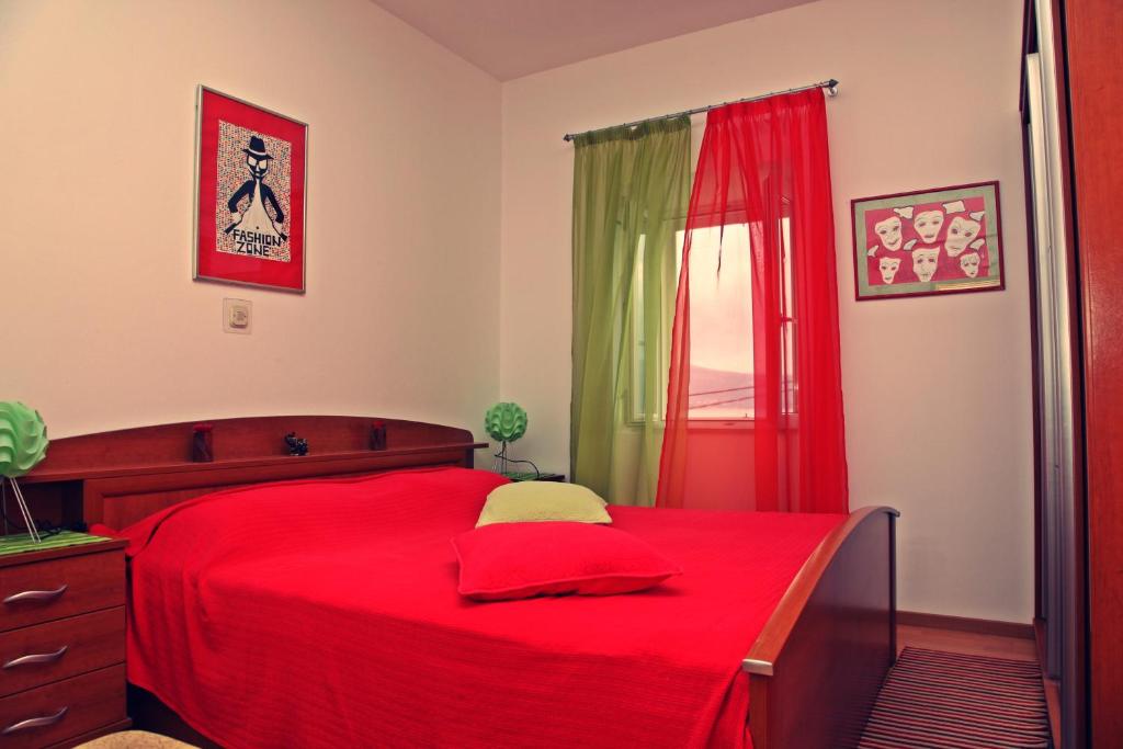 sypialnia z czerwonym łóżkiem i czerwonym oknem w obiekcie Apartments and rooms by the sea Lumbarda, Korcula - 14647 w mieście Lumbarda