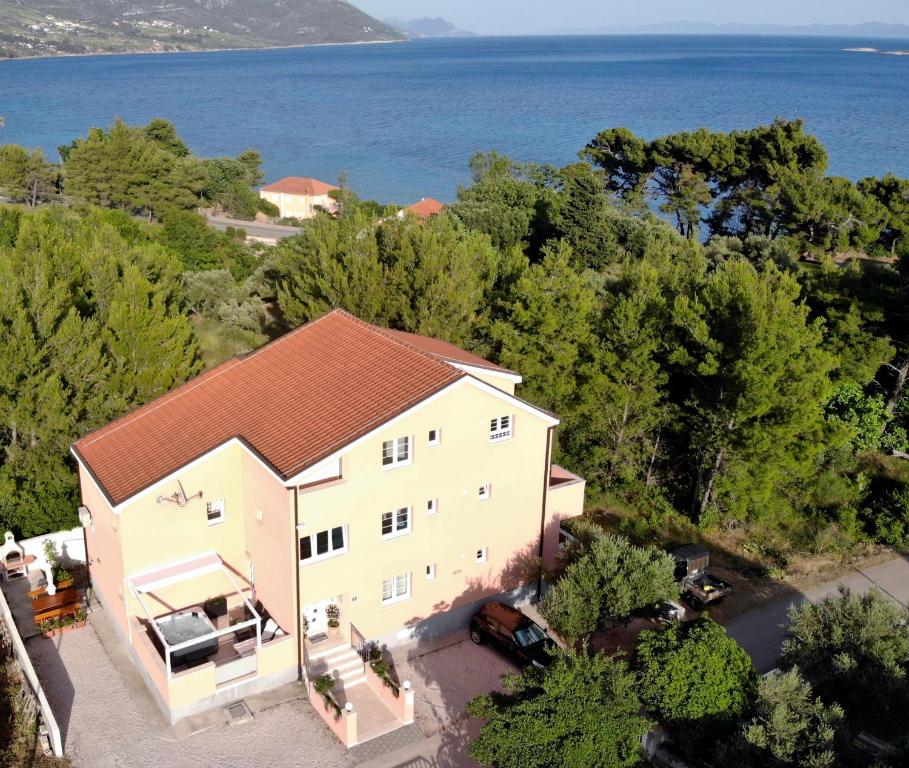 eine Luftansicht eines weißen Hauses mit rotem Dach in der Unterkunft Apartments by the sea Orebic, Peljesac - 14767 in Orebić