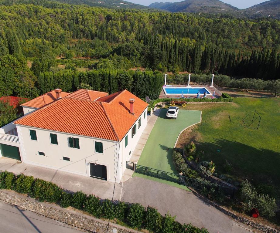 Una vista aérea de una casa blanca con un techo naranja. en Luxury villa with a swimming pool Zastolje, Dubrovnik - 14922, en Gruda