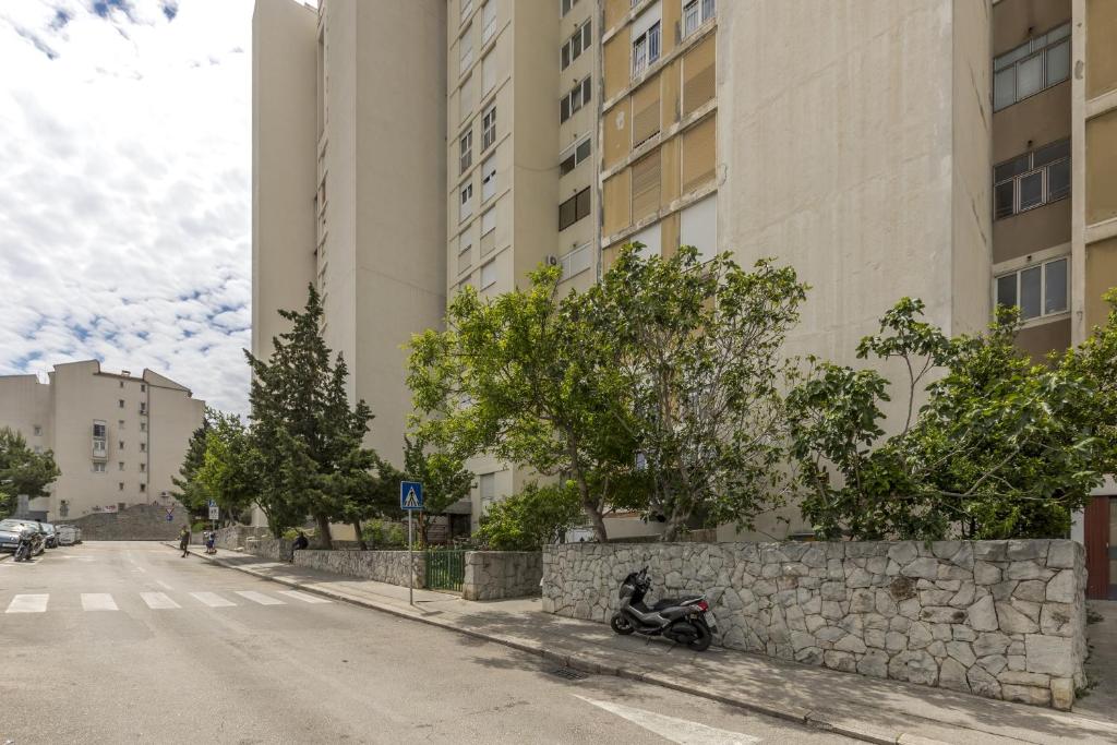 una moto estacionada en el lado de una calle con edificios en Apartments with WiFi Split - 14921 en Split