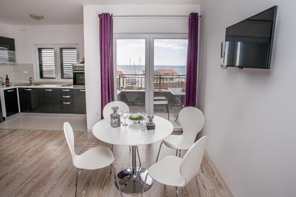 a white table and chairs in a room with a kitchen at Apartments with a parking space Sumpetar, Omis - 14941 in Jesenice