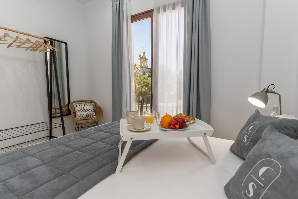 - une chambre avec un lit et une table avec des fruits dans l'établissement Córdoba Suites Apartments, à Cordoue