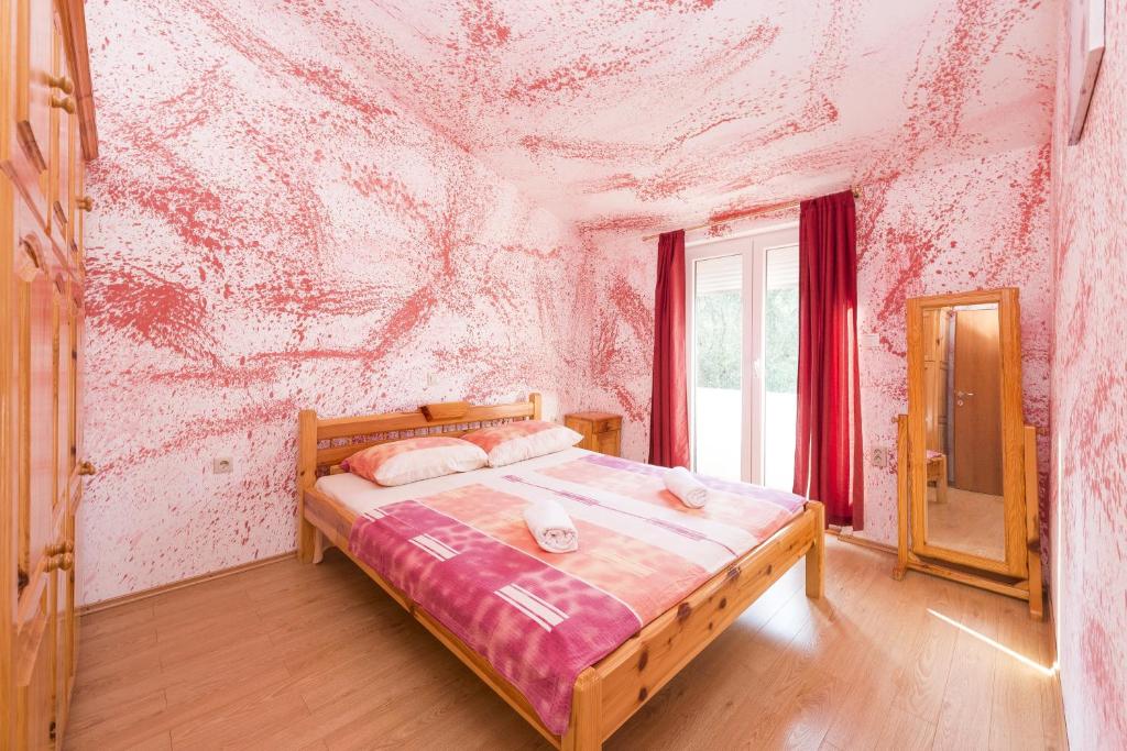 - une chambre avec un lit en face d'un mur rose dans l'établissement Apartments with a parking space Poljana, Ugljan - 15019, à Poljana