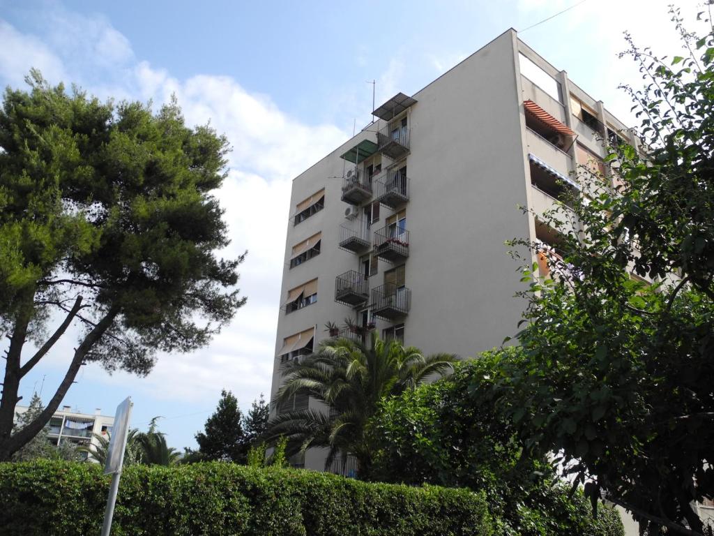 a white apartment building with trees in front of it at Apartments with WiFi Split - 15028 in Split