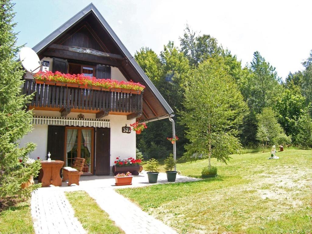 una casa con un balcón con flores. en Holiday house with a parking space Crni Lug, Gorski kotar - 15058 en Crni Lug