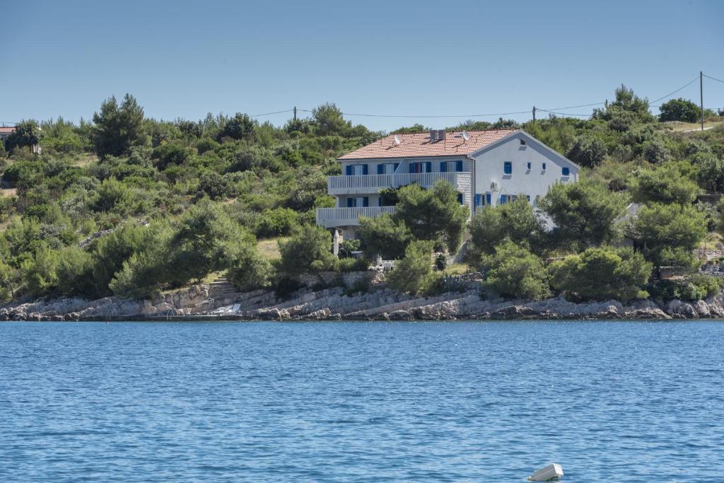 a house on a hill next to a body of water at Apartments by the sea Cove Pribinja, Hvar - 15083 in Hvar