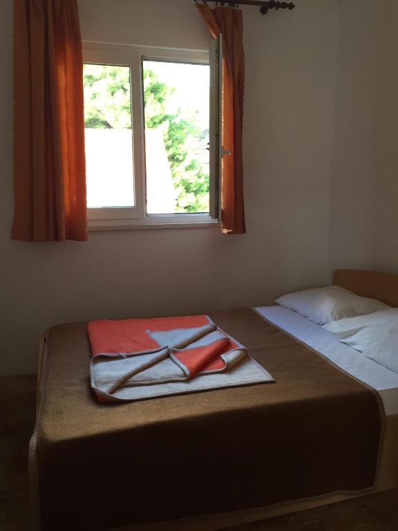 a bed with two towels on it with a window at Apartments with a parking space Orebic, Peljesac - 15086 in Orebić