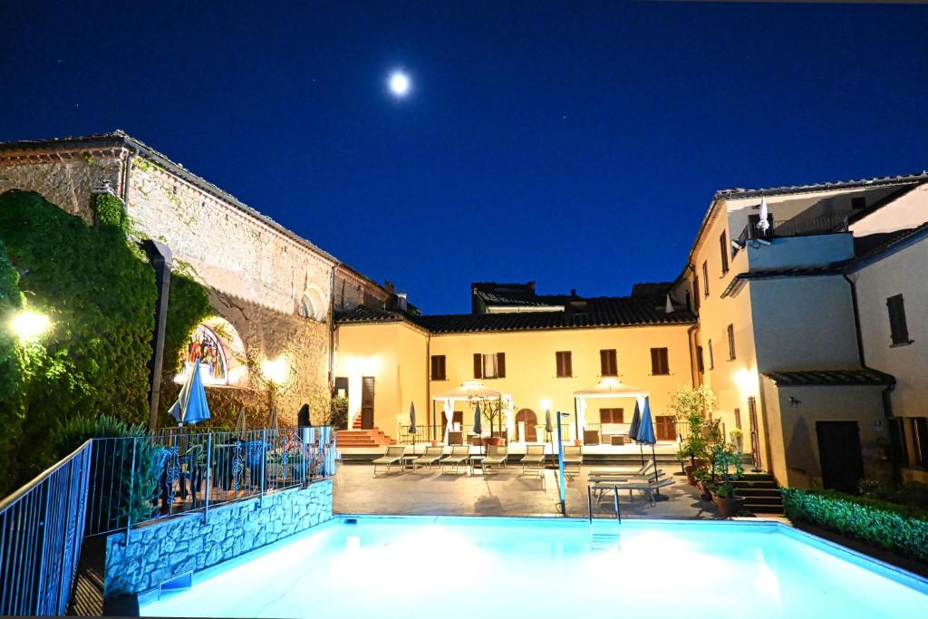 a house with a swimming pool at night at Hotel San Lino in Volterra