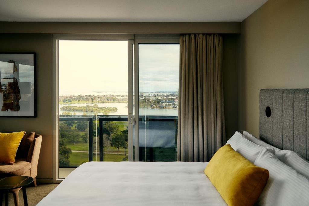 a bedroom with a bed and a large window at The Kinson in Melbourne