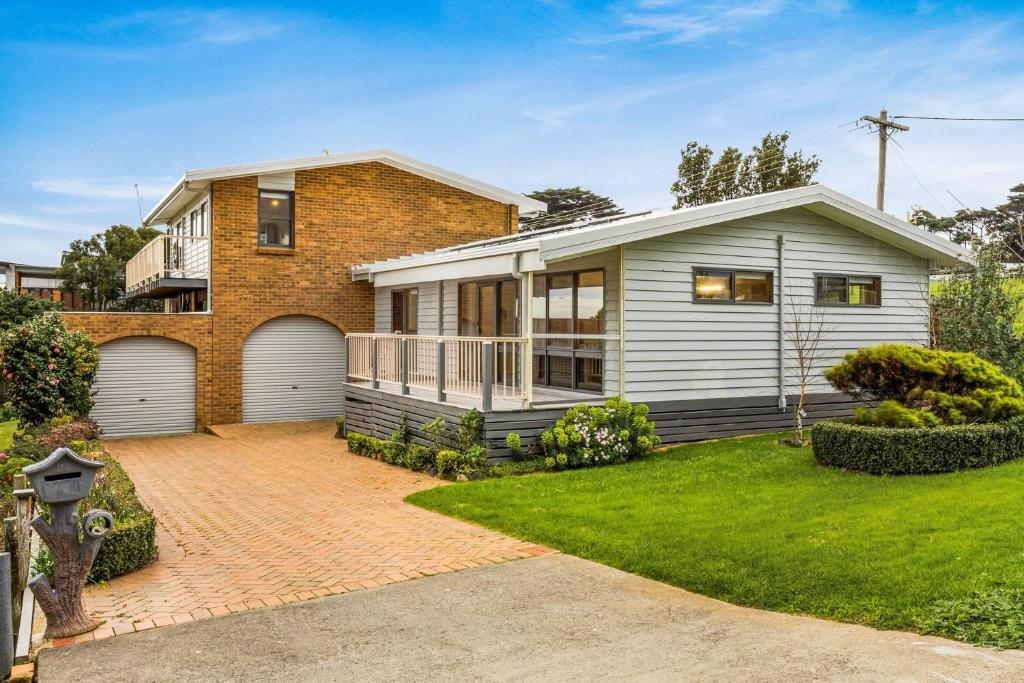 a house with a garage and a grass yard at Views on Broadway in San Remo