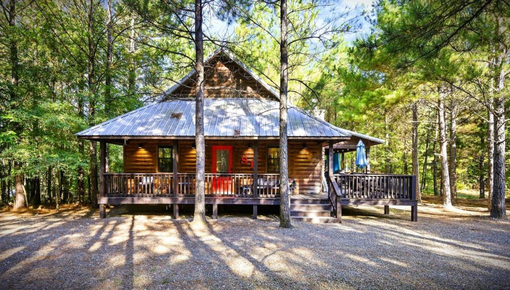 a log cabin in the middle of a forest at Shear Pleasure in Broken Bow