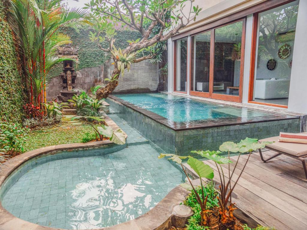 a swimming pool in the middle of a yard at AB Villa & Apartments in Seminyak