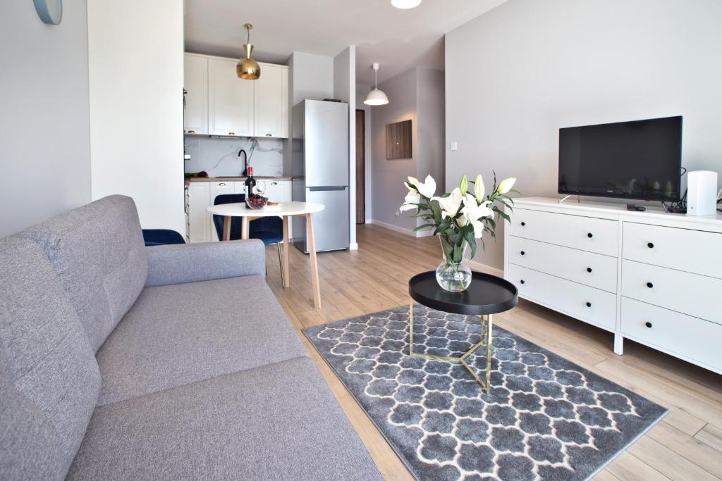 P&O Serviced Apartments Posag 7 Panien - Ursus في وارسو: غرفة معيشة مع أريكة وطاولة