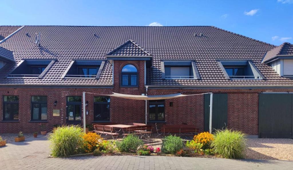 - un bâtiment en briques avec une terrasse et une table dans l'établissement Landapartments Smitmans, à Kerken