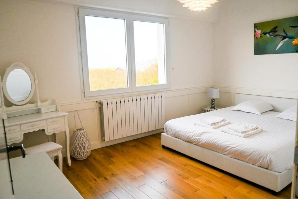 a white bedroom with a bed and a mirror at Résidence Le Lenn-louannec - Maisons &amp; Villas pour 6 Personnes 784 in Lannion