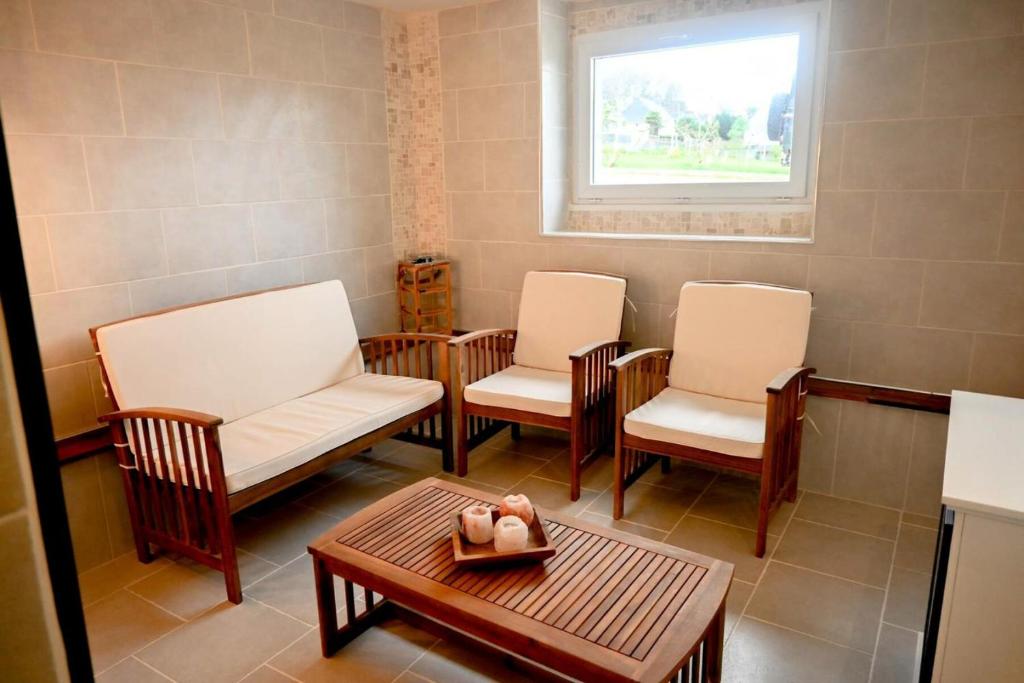 a waiting room with chairs and a table and a window at Résidence Le Lenn-louannec - Maisons &amp; Villas pour 6 Personnes 784 in Lannion