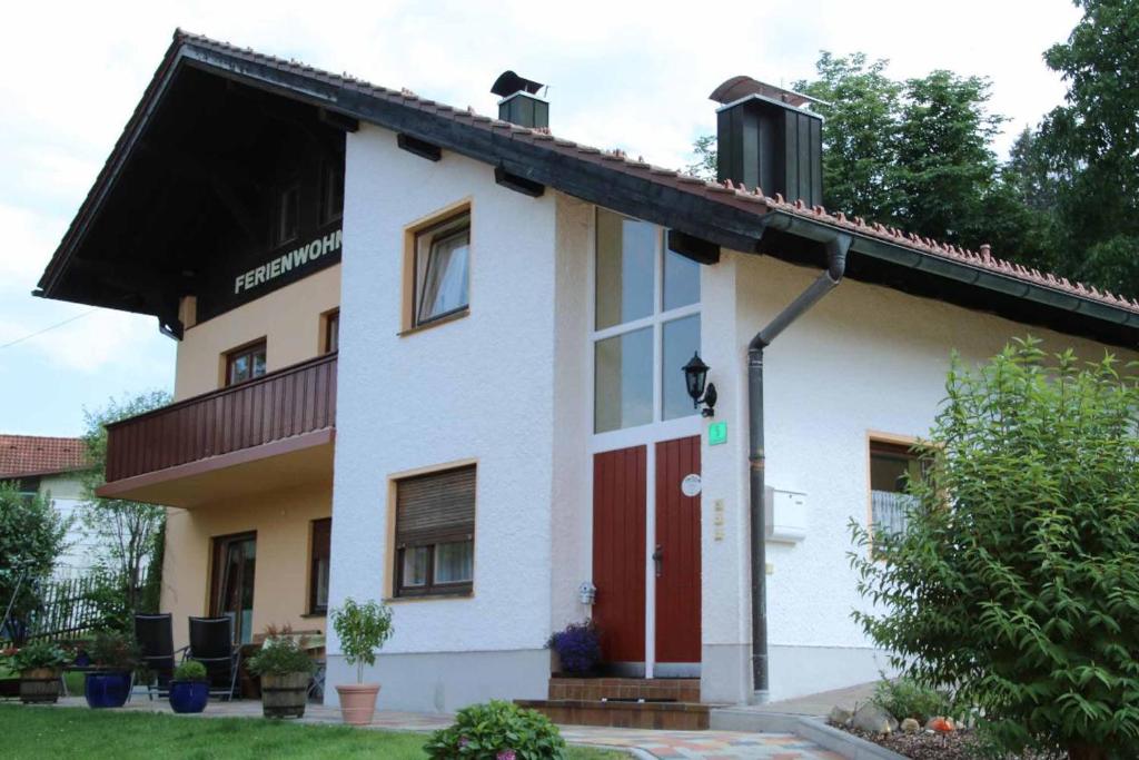 a white house with a red door at Ferienwohnung Bärnbachl in Bayerisch Eisenstein