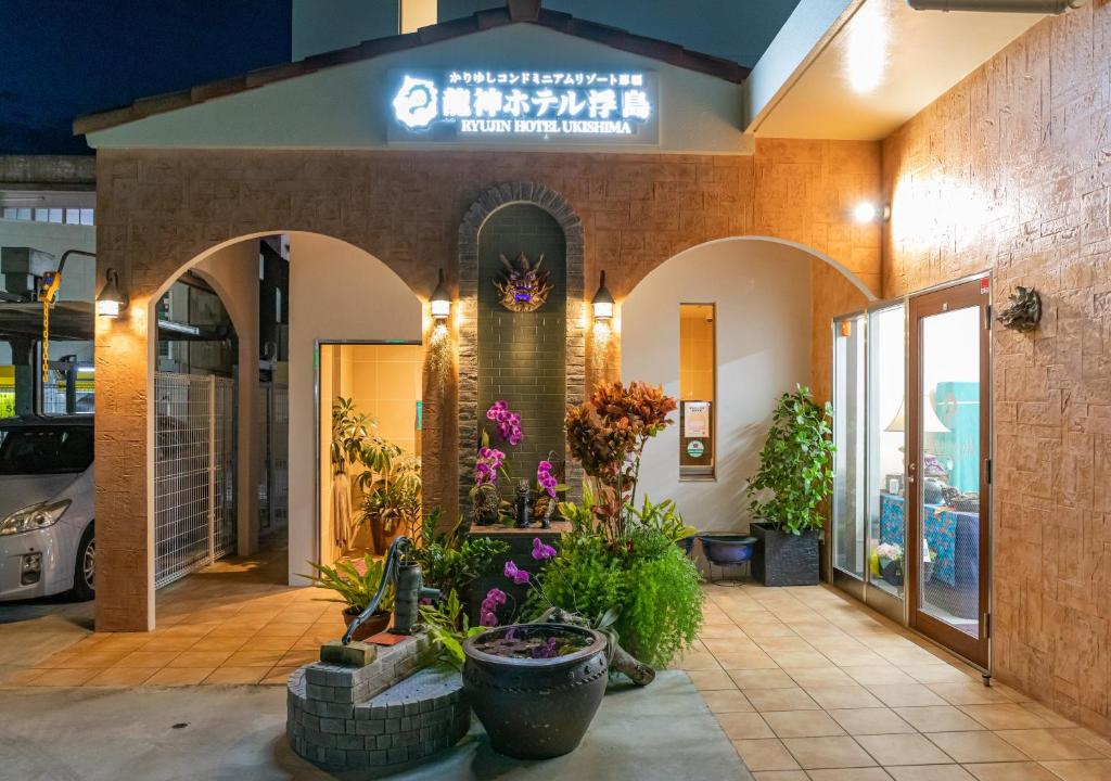 a building with plants and flowers in front of it at Ryujin Hotel Ukishima in Naha