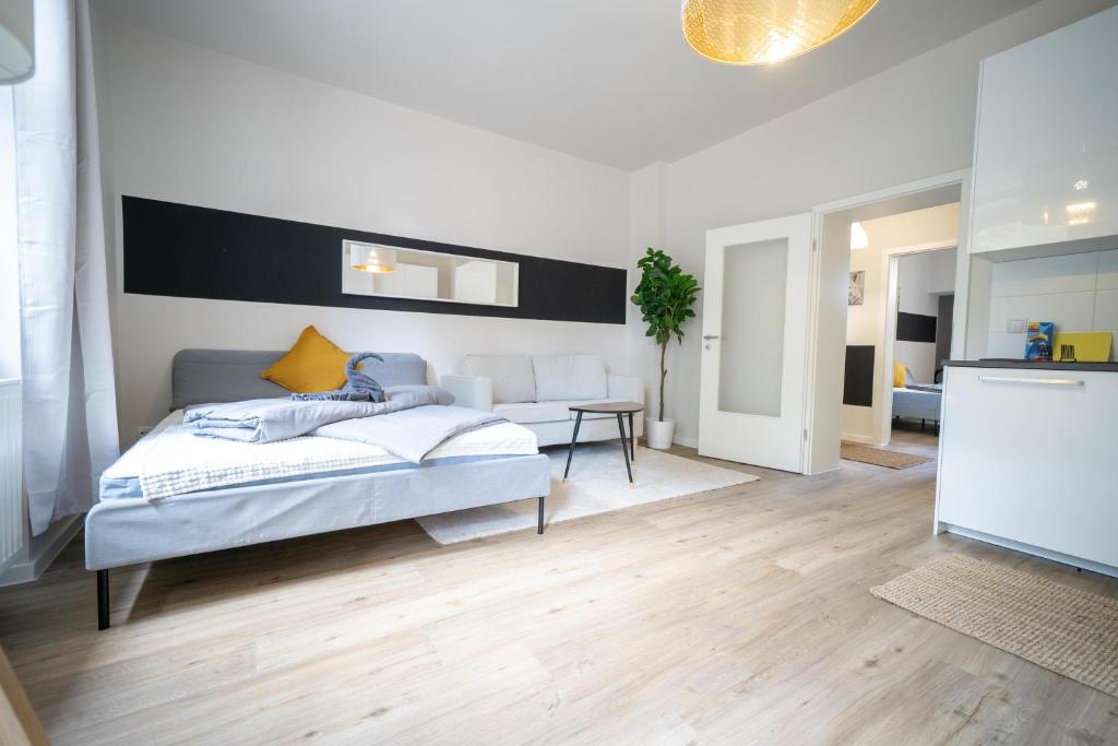 a bedroom with a bed and a living room at FULL HOUSE Studios - L96 2 Bedroom Apartment in Zwickau