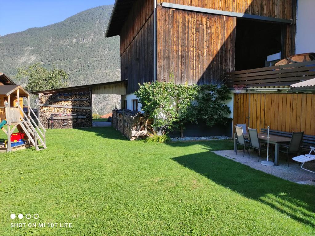 a house with a yard with a table and chairs at groassehof Haus Gstrein in Imsterberg