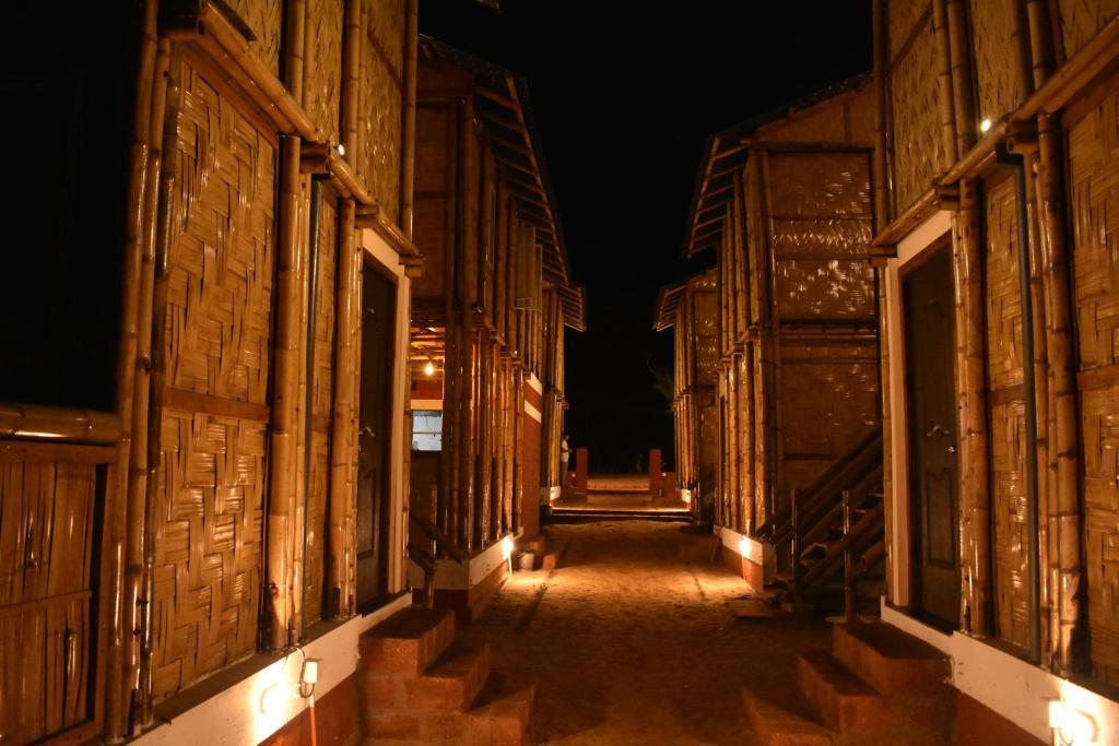 an empty alley way at night with lights at Chivarin Resorts in Malvan