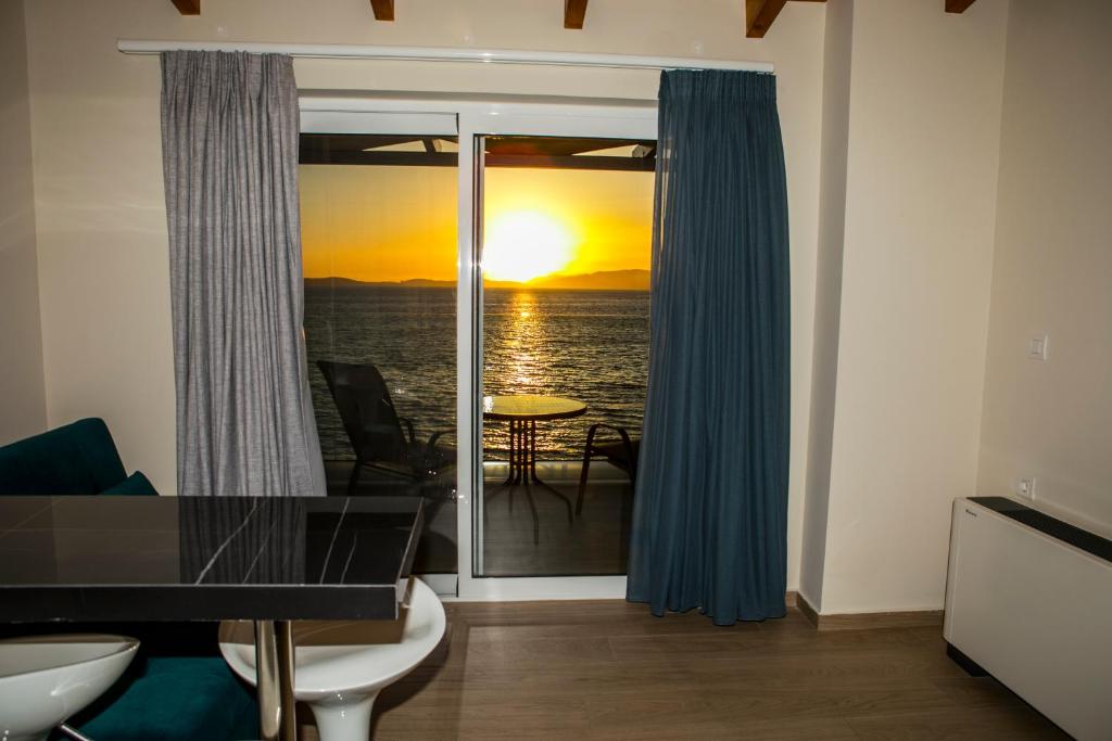 a living room with a view of the ocean at HOTEL ALEXANDER in Mýtikas