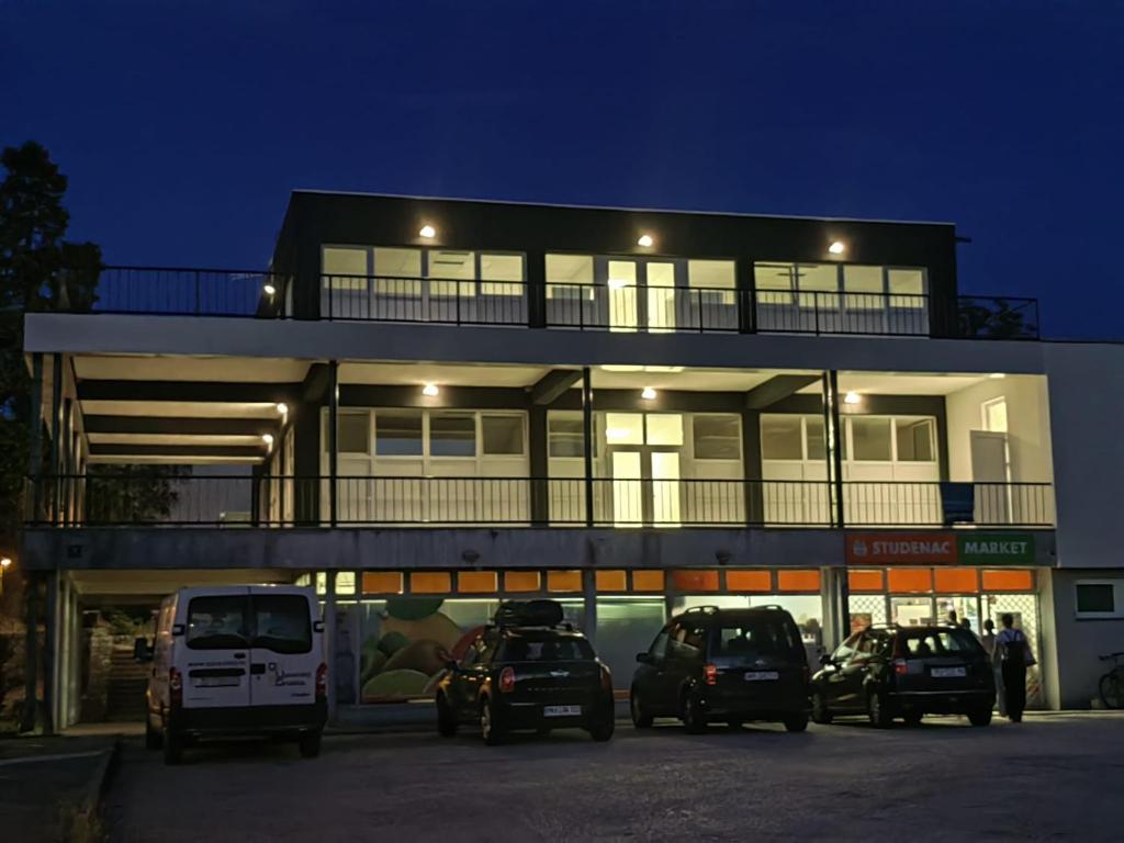 un bâtiment avec des voitures garées dans un parking dans l'établissement Hostel Potpican, à Potpićan