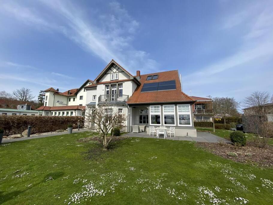 a large white house with a solar roof at Fewo in Villa mit Seeblick in Plau am See