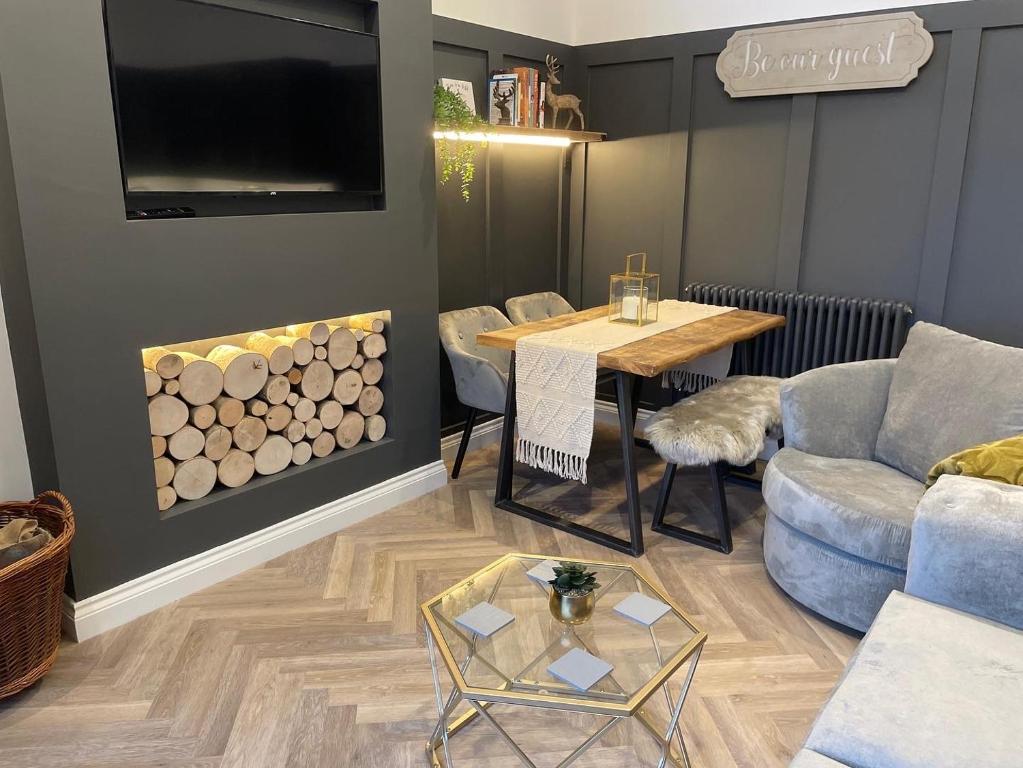 a living room with a table and a couch at Cedar Lodge in Crawshaw Booth