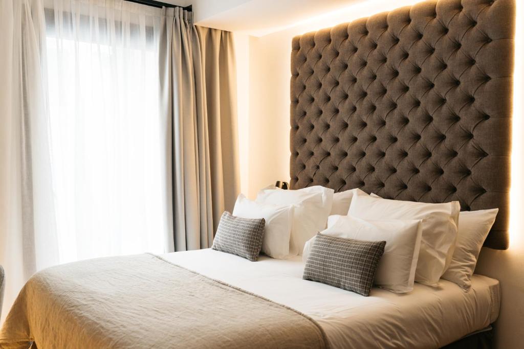 a bedroom with a large bed with a large window at Boutique Hotel Petit Montisión in Palma de Mallorca